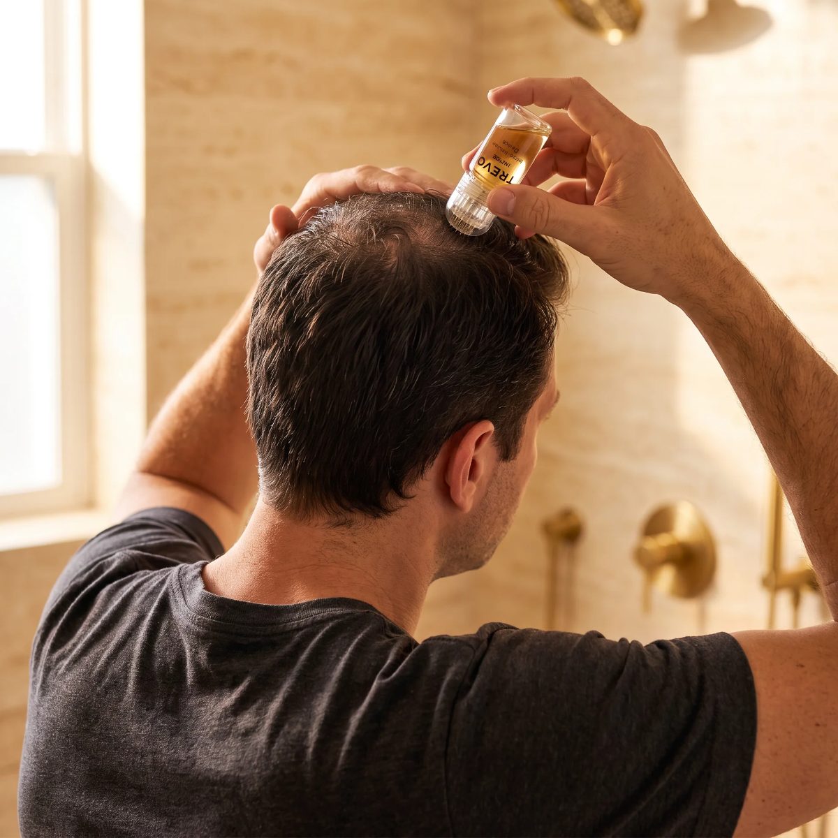 Man stamping his crown with the TREVO micro-infusion device in a bathroom